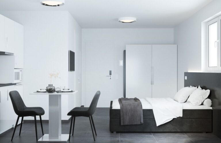 Geräumiges, minimalistisches Schlafzimmer in Schwarz-Weiß mit kleinem Esstisch und zwei Stühlen.